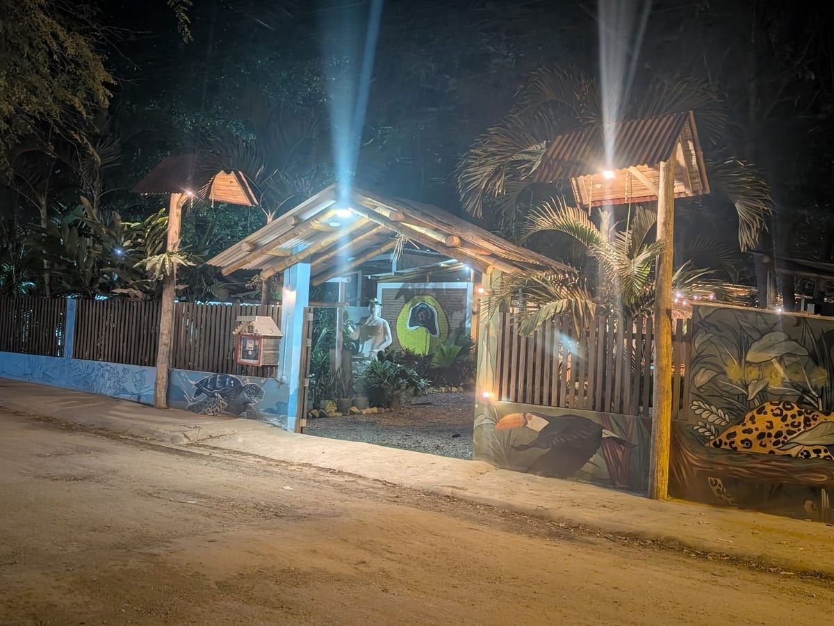 The entrance to The Surfing Cowboy Cantina at night, lit under a bamboo archway